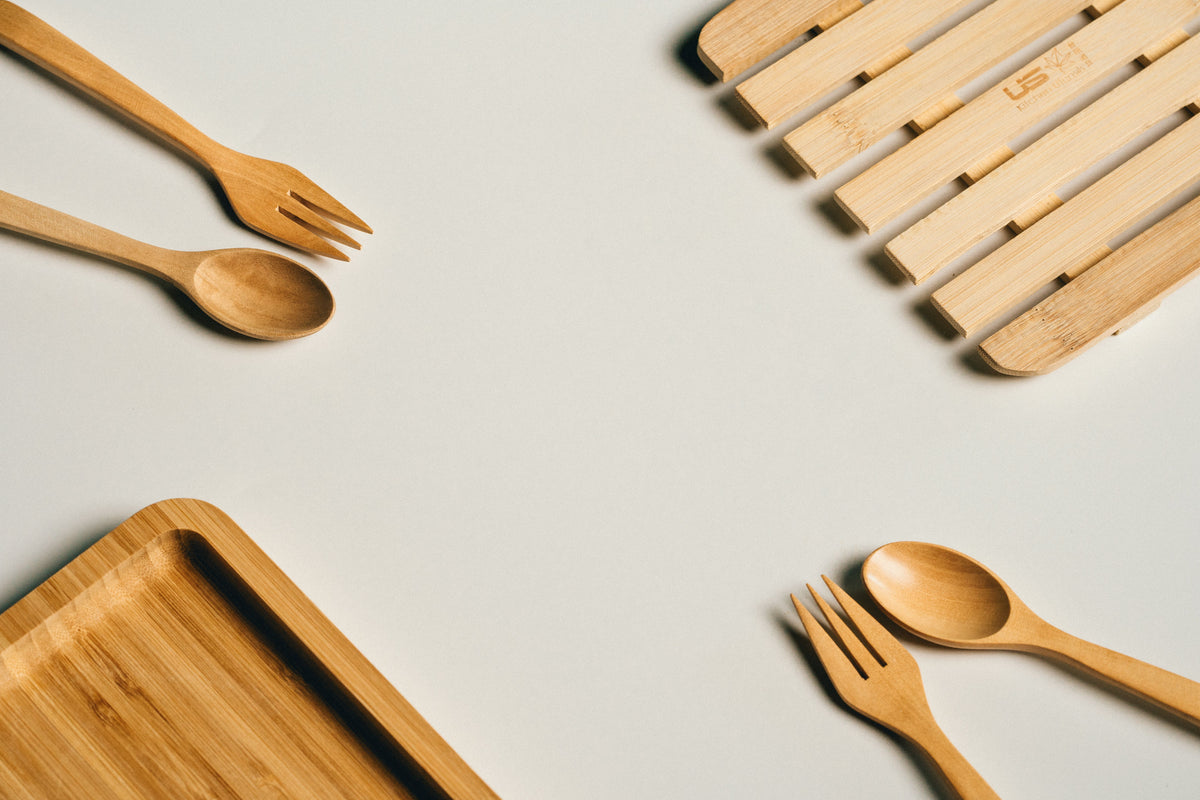 Wooden cutlery and trays on a light gray background